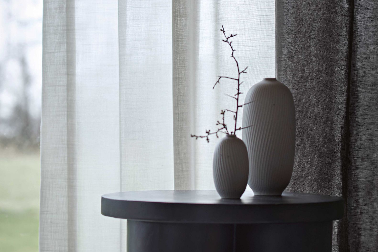 Anfassen erwünscht! Denn die Textilien des Familienunternehmens überzeugen nicht nur optisch, sondern auch aufgrund ihrer angenehmen Haptik: Weich wie ein zartes Wolltuch präsentiert sich der naturfarbene Vorhangstoff «Harmony» aus reiner Schurwolle. Von festerer Struktur hingegen ist der dunkle Dekostoff «Ari» aus Leinen und Kunstfaser. LUIZ.COM