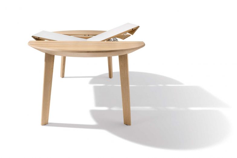 Seine runde Tischplatte macht «Miró» zu einem Ort der Begegnung. Und das nicht ohne handwerkliche Raffinesse: Die abgeschrägte Oberkante der Tischplatte lässt den massiven Tisch filigran wirken. Die Einlegeplatte, die den Tisch um 50 Zentimeter vergrössert, ist klug unter der Platte verstaut. TEAM7-HOME.COM