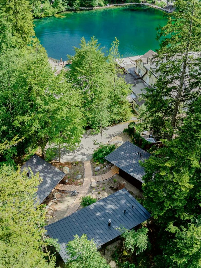 Blick von oben. Wer den See von seinem Waldhaus trotzdem sehen will, geht einfach zur Tür raus. Jedes Haus verfügt über eine kleine Terrasse auf der Rückseite des Hauses. Ansonsten hat man in den drei Häusern viel Privatsphäre und den uneingeschränkten Blick ins Grüne. Foto: André Maurer Photography.