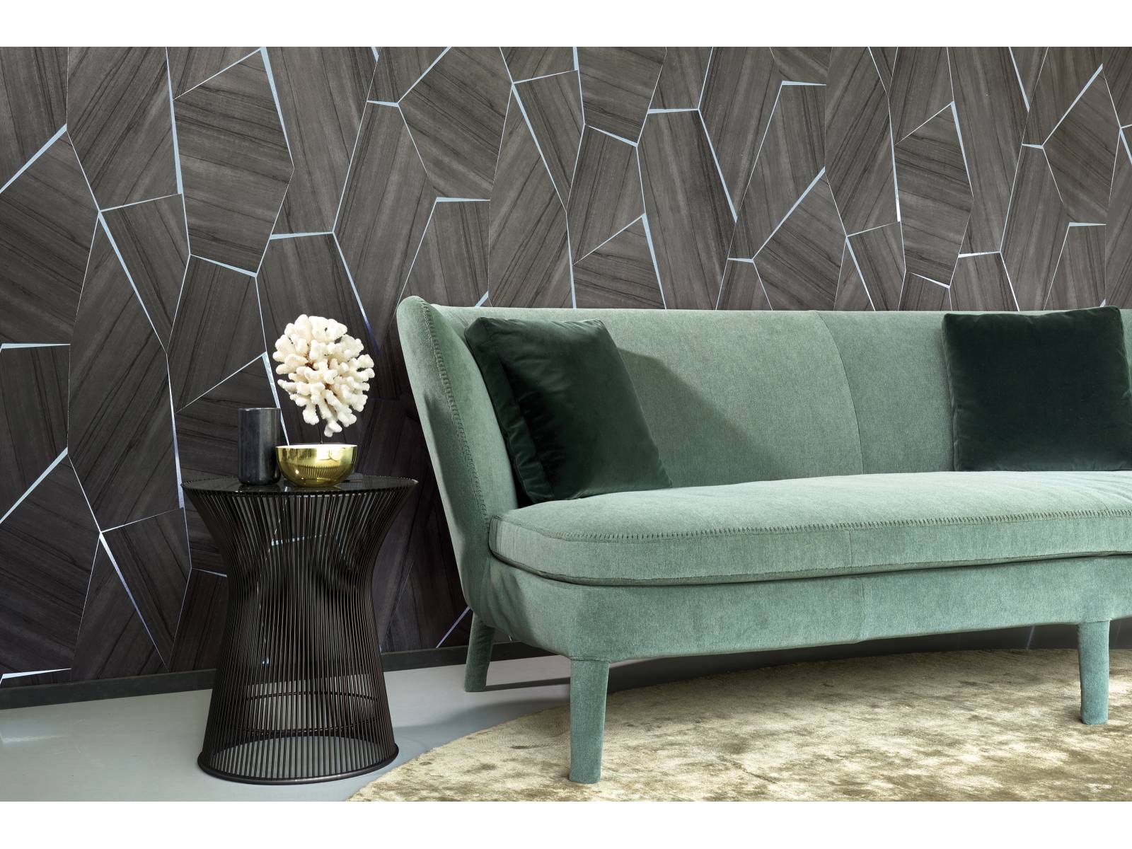 Die Wandverkleidung «Section» ist aus Nussbaumholz und wird mit glänzenden Edelmetall-Linien kombiniert. Dabei werden die einzelnen Elemente wie ein Patchwork zusammen gefügt, was ein lebendiges Muster hervor ruft. Aus der Wildwalk-Kollektion. Arte International.