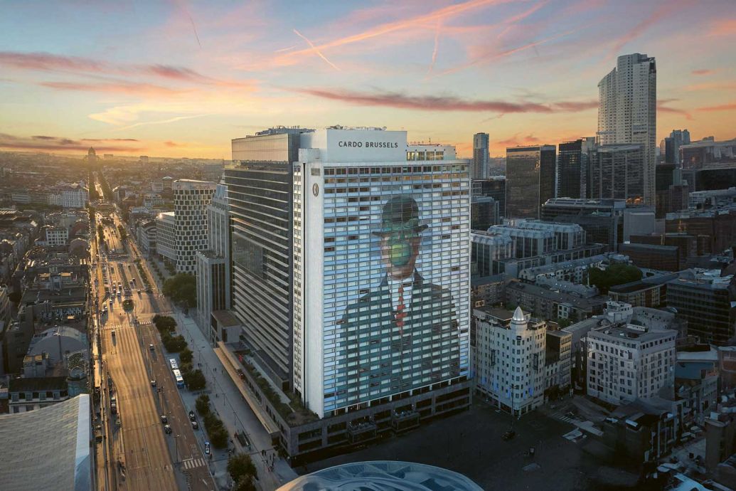 Brüssels grösstes Hotel ist das Cardo, das zu Marriotts Autograph Collection zählt. Es erweist dem belgischen Maler und Surrealisten René Magritte die Ehre: Sein ikonisches Selbstporträt «Der Sohn des Menschen» nimmt die fast 75 m hohe Fassade an der belebten Place Rogier ein. Und auch beim Eingang des 532-Zimmer-Hotels mit Indoor-Pool wird der Meister inszeniert: Dort gibt es eine interaktive Videoinstallation. Nähert sich der Gast dem Bildschirm, erscheint er als Cartoon oder als René-Magritte-Avatar. Innenarchitektur mit Augenzwinkern ist das Markenzeichen des Selfmade-Interior-Stars Saar Zafrir, der für das Cardo eine Reihe massgeschneiderter Möbel entwarf: Comics und ihre Sprechblasen hatten einen erheblichen Einfluss auf das Design.  cardohotels.com