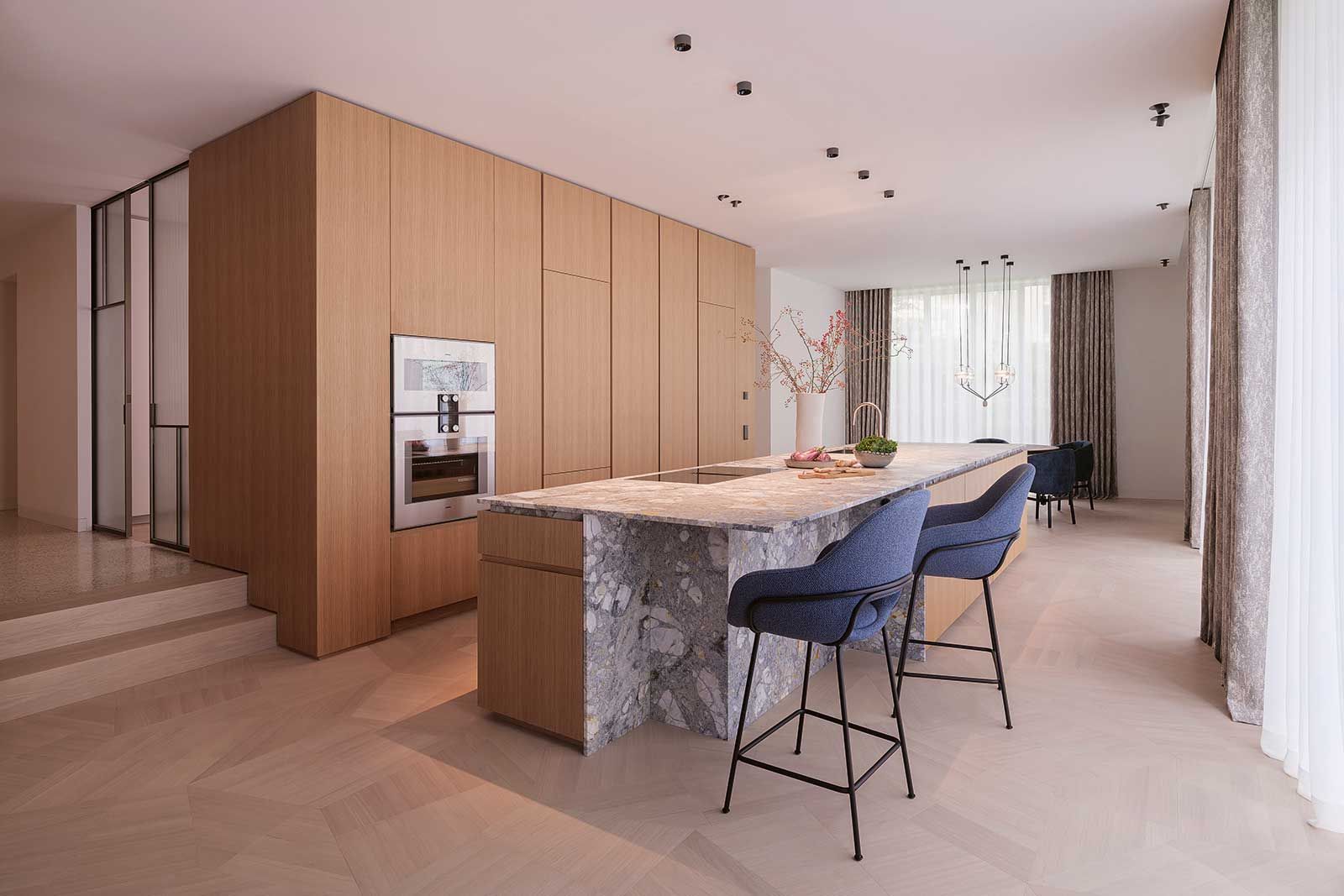 Küche und Essbereich liegen zwei Treppenstufen tiefer als der ­Eingangsbereich – ein subtiler Wechsel der Ebenen, der den Räumen Struktur verleiht.