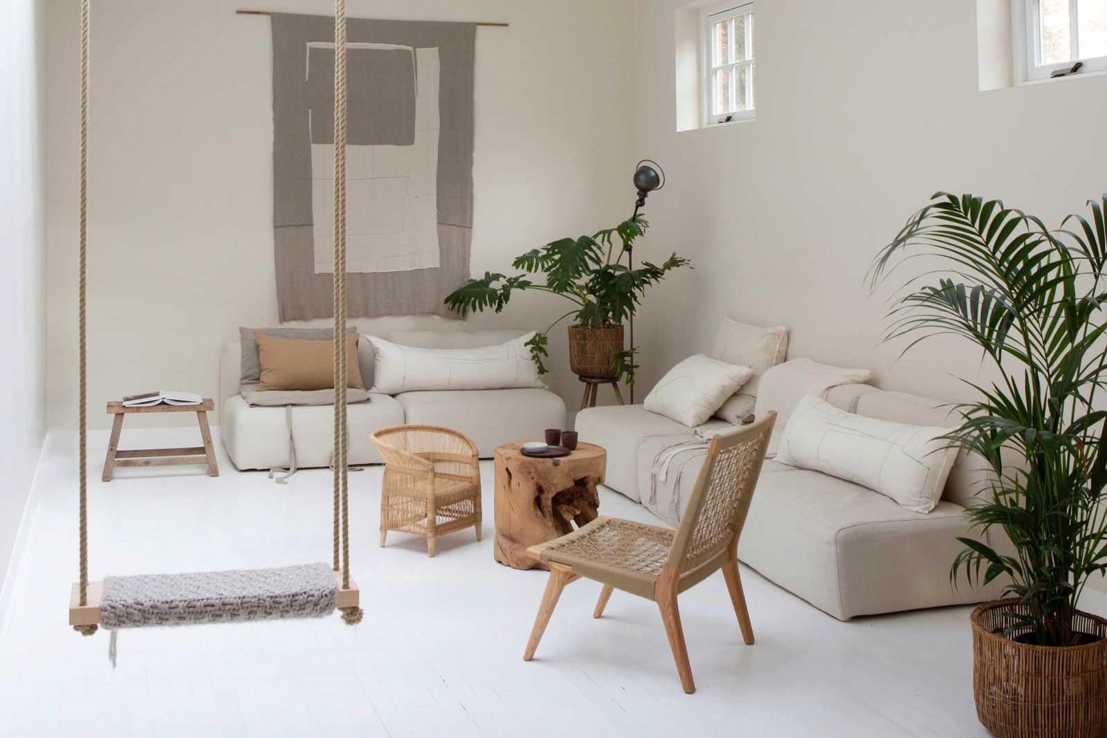 Das Wohnzimmer ist Teil des Geschosses und war früher Bäckerei und Garage. Heute ist es der perfekte Platz, um der Hektik der niederländischen Hauptstadt zu entfliehen. Die Kissen aus belgischem Leinen und der Patchwork-Wandteppich «Nomad» aus alten Stoffen und Stoffresten sind von «Fant Projects». Der Baumstammtisch ist ein Entwurf für das eigene Label Atelier Sukha. Leuchte: Jieldé.