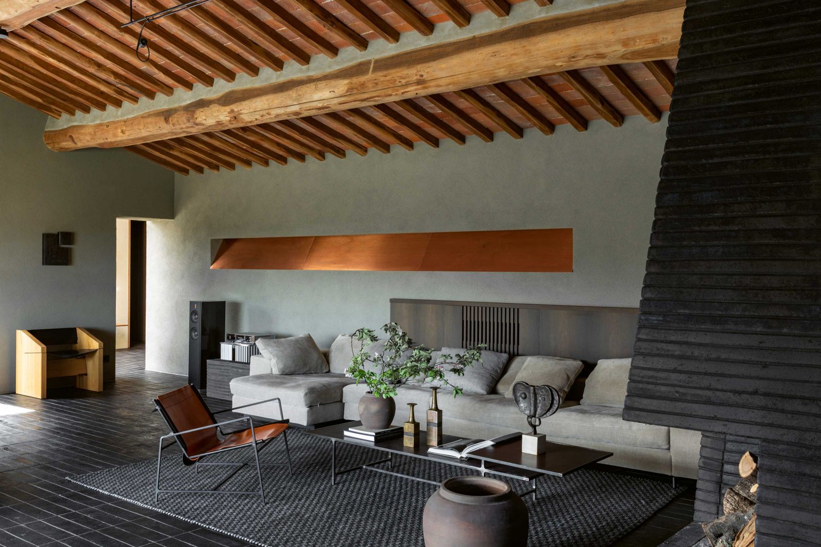 Die Casa Morelli ist kein typisch hell gestaltetes Sommerhaus. Die grosszügigen Fensterflächen erlaubten eher dunkel gestaltete Innenräume, die viel Wärme ausstrahlen. Sofa: De Padova.