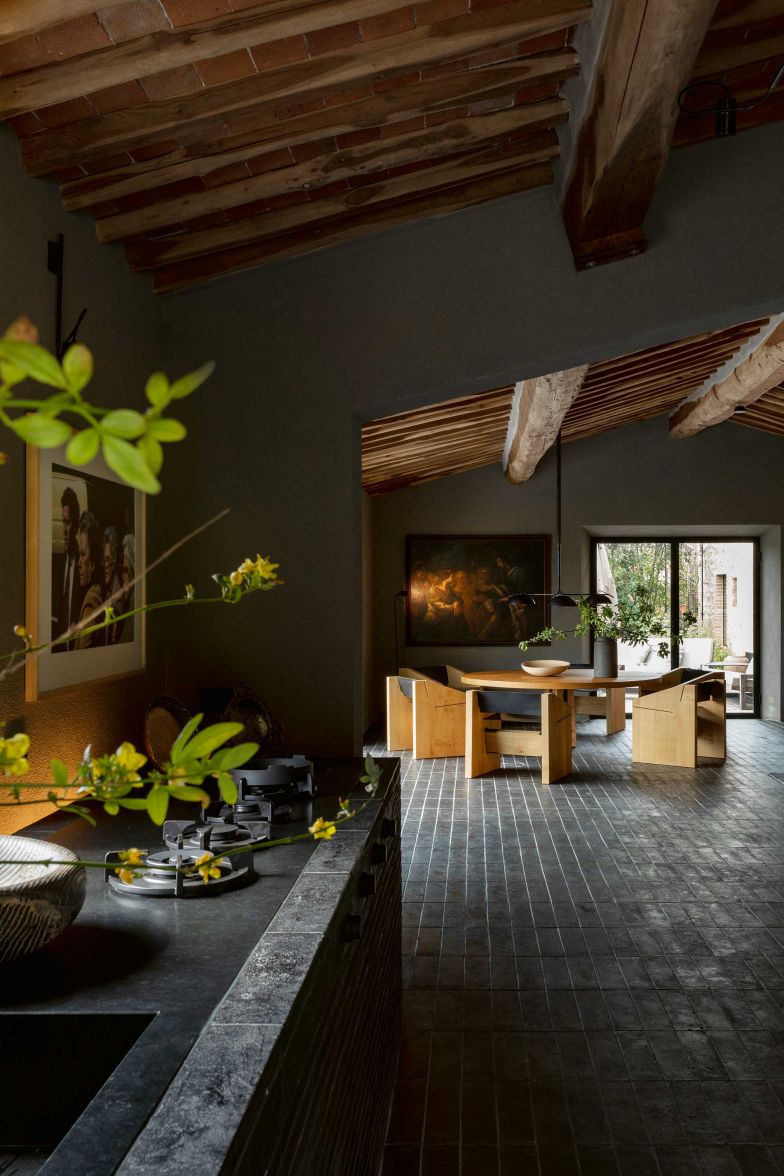 Die Küche ist offen gestaltet und führt nahtlos über in den Wohnraum. Von hier aus kann man den Cotto-Boden bewundern, für den der Hersteller Manetti eigens für das Projekt 14 000 Platten im Farbton Anthrazit von Hand gefertigt hat. 